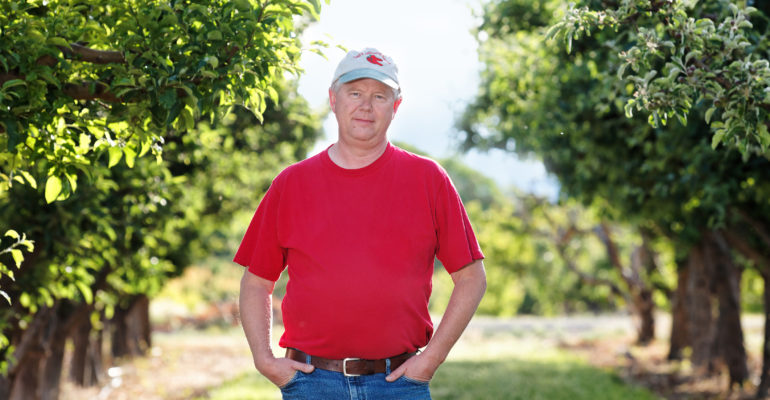 Tom Walcher, farmer, in orchard