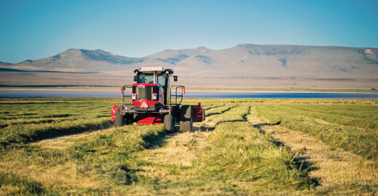 harvesting farm equipment in alfalfa field