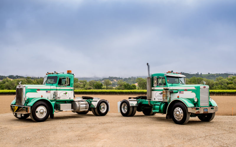 two big rig trucks in front of vineyards, farm credit leasing for fleet equipment