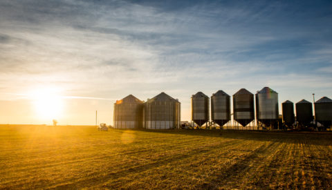 American AgCredit truck from a distance in front of silos at sunset