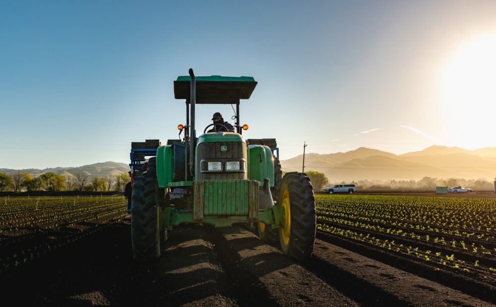 Green tractor in a large field