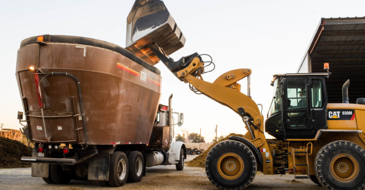 Large machine dumping product into a truck