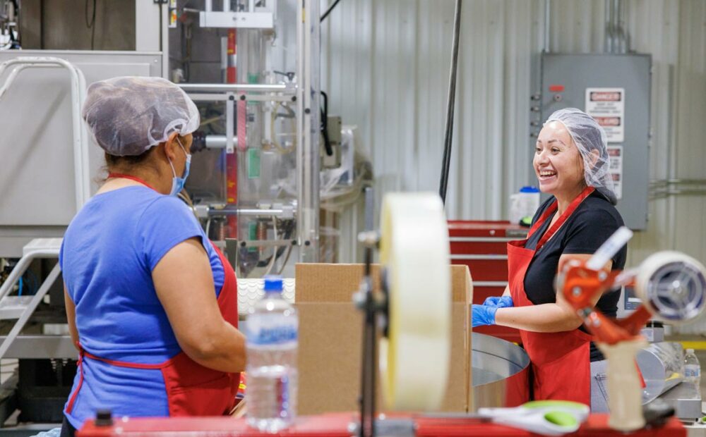 New Mexico processing facility worker laughing with coworker