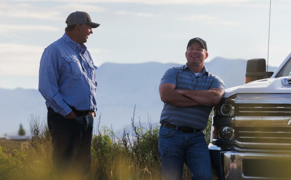 Smiling American AgCredit customer next to truck