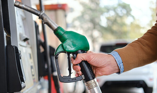 Side view detail man fueling car at gas station cropped