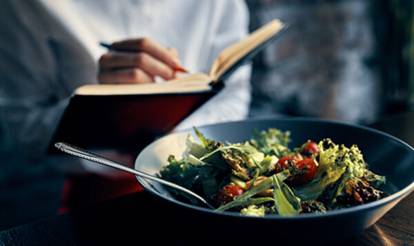 Woman with notepad near the window with salad 1